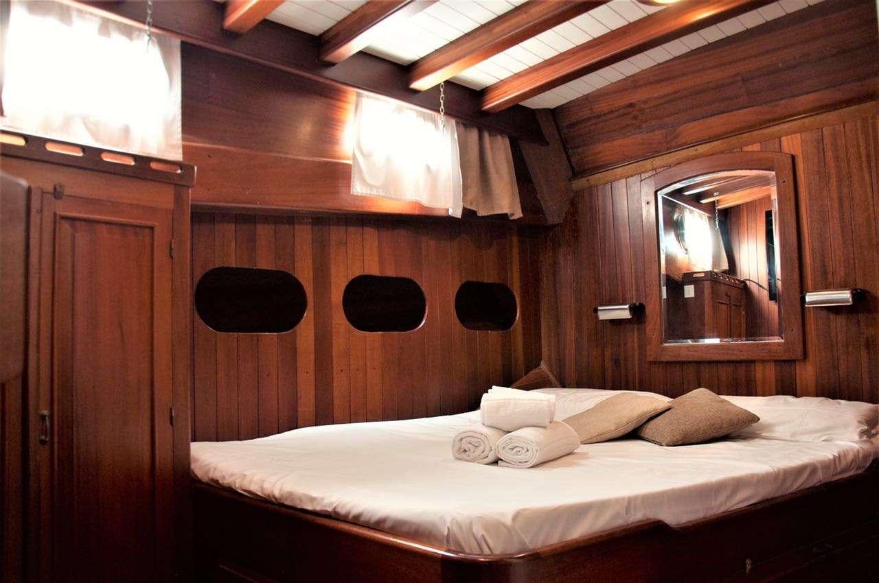 a bed with a mirror above it aboard Donna Marisa Yacht for Charter