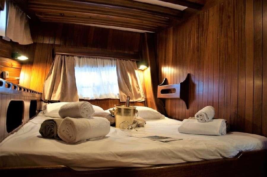 a bed with white sheets and pillows aboard Donna Marisa Yacht for Charter