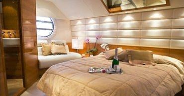 a room with a bed and a glass of wine aboard GEORGE V Yacht for Charter