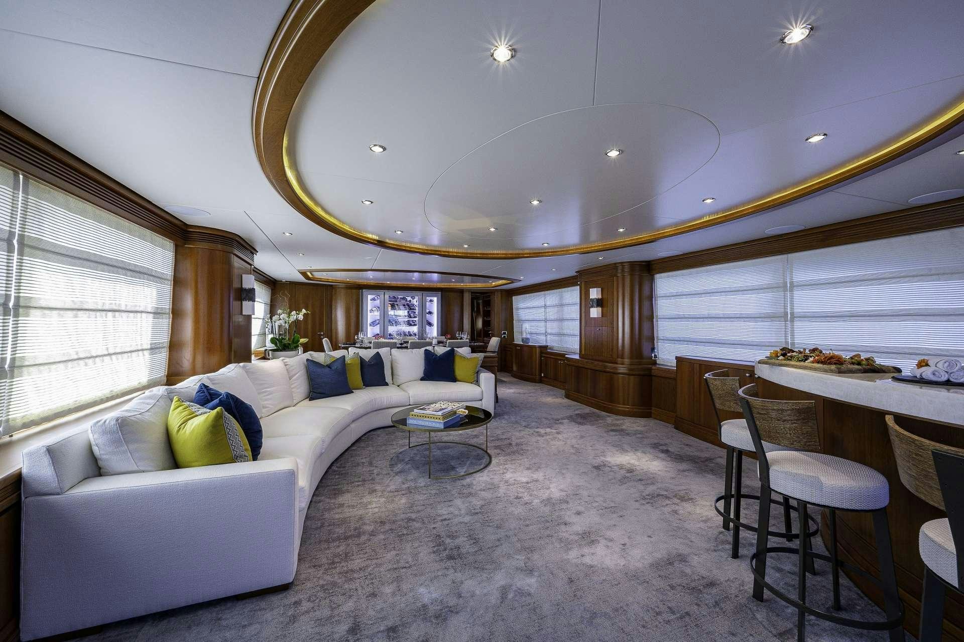 a large living room with a large white couch and a large window aboard SWEET EMOCEAN Yacht for Charter