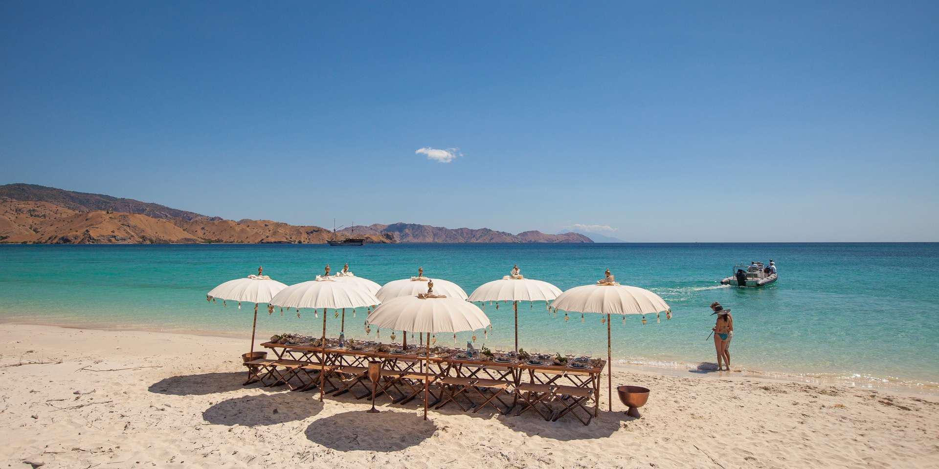 a beach with umbrellas and chairs aboard PRANA Yacht for Charter