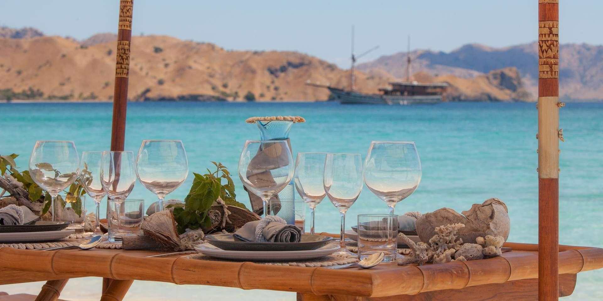 a table with wine glasses and food on it aboard PRANA Yacht for Charter