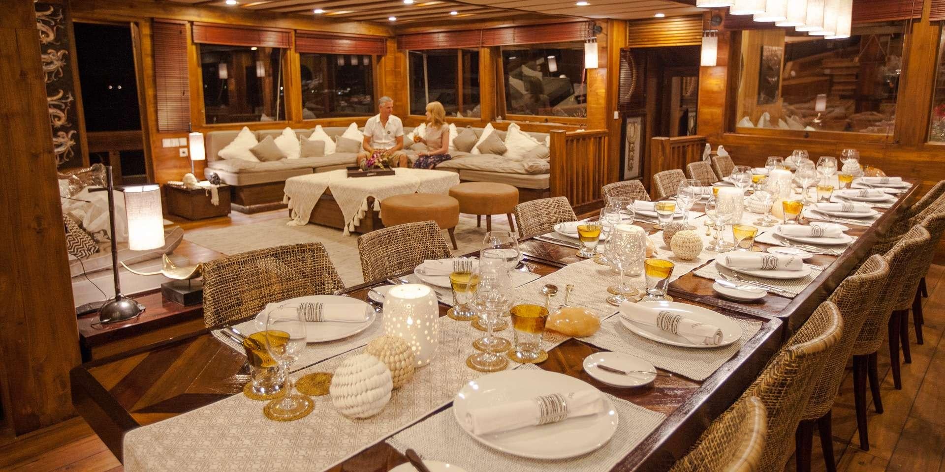 a group of people sitting at a table with plates and glasses aboard PRANA Yacht for Charter