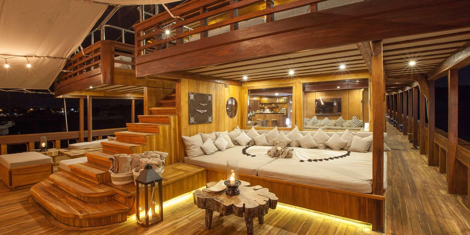 a large room with a bed and a table aboard PRANA Yacht for Charter