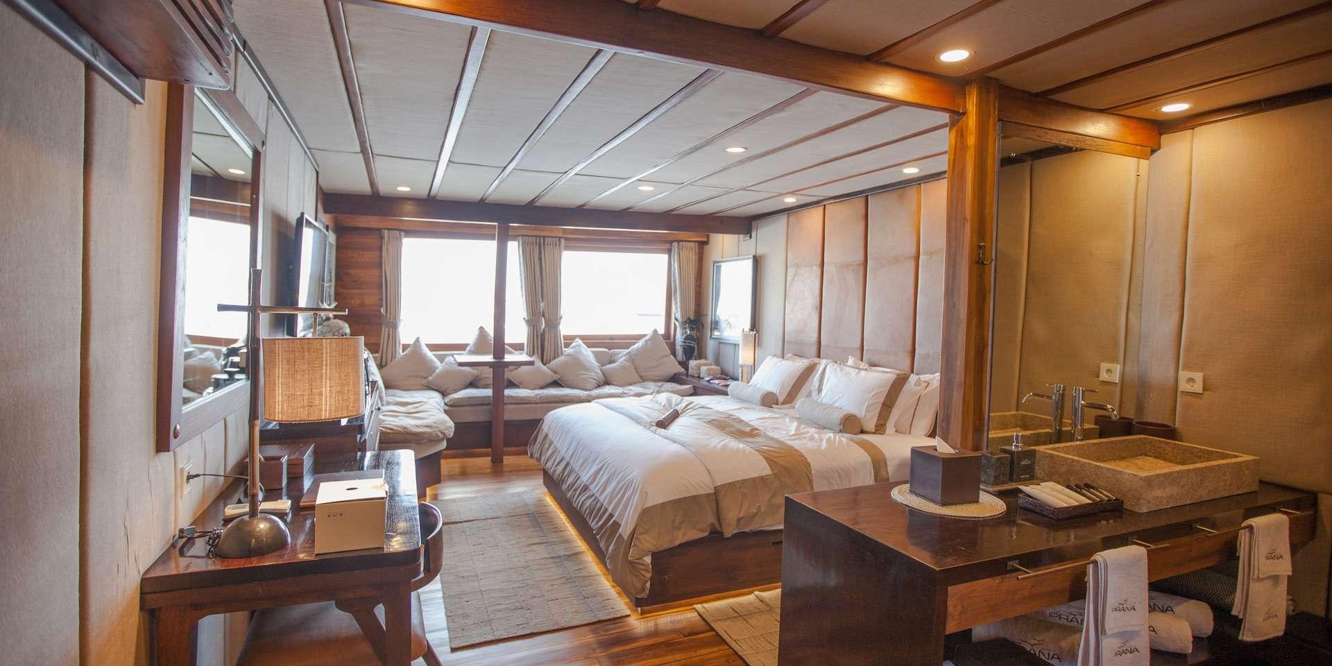 a room with a bed and a table aboard PRANA Yacht for Charter