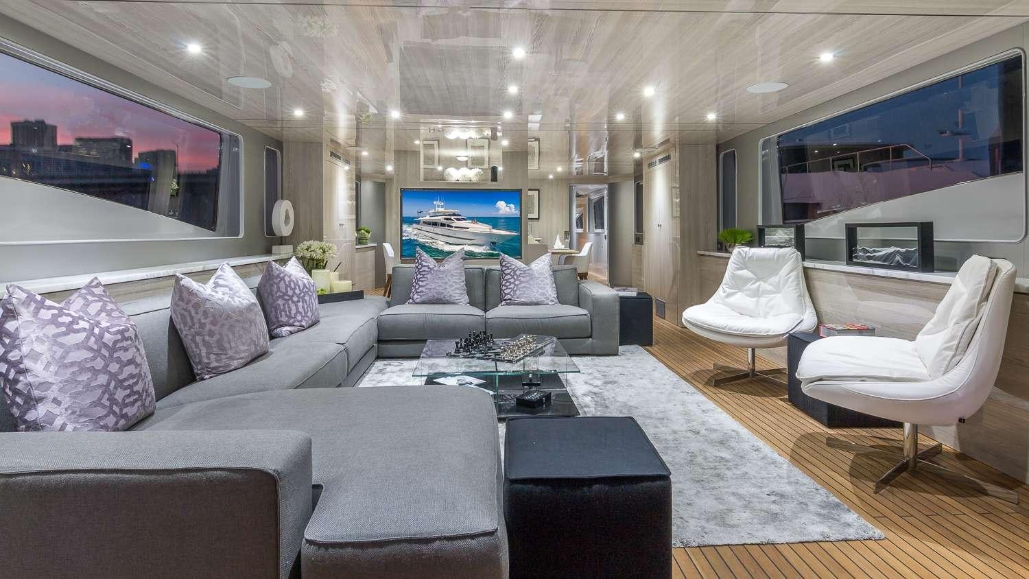 a living room with a large blue and white couches aboard NIRVANA Yacht for Charter
