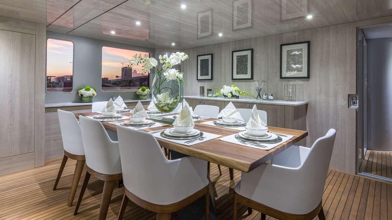 a table with chairs and a vase on it aboard NIRVANA Yacht for Charter