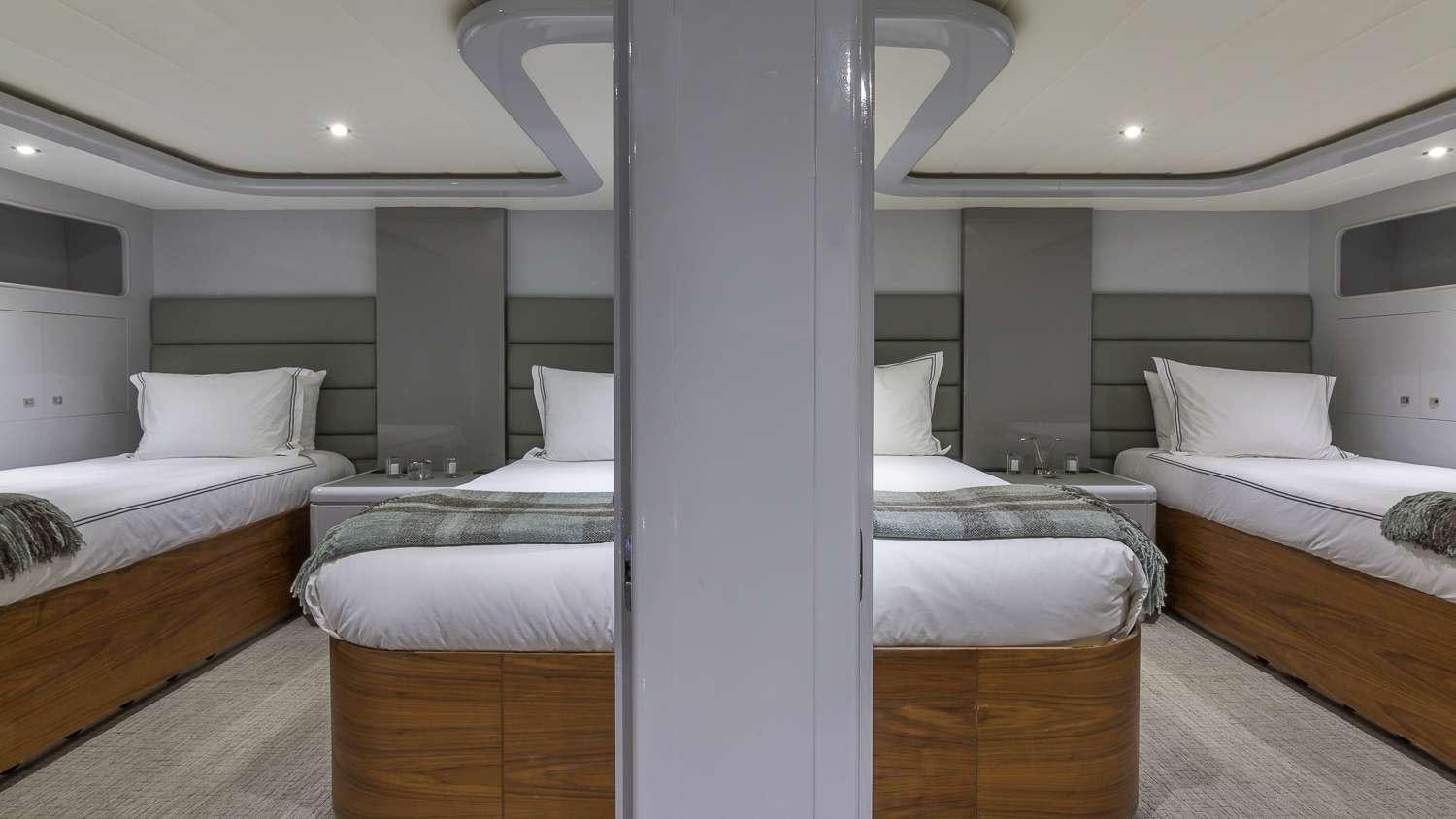 a room with beds and a large mirror aboard NIRVANA Yacht for Charter