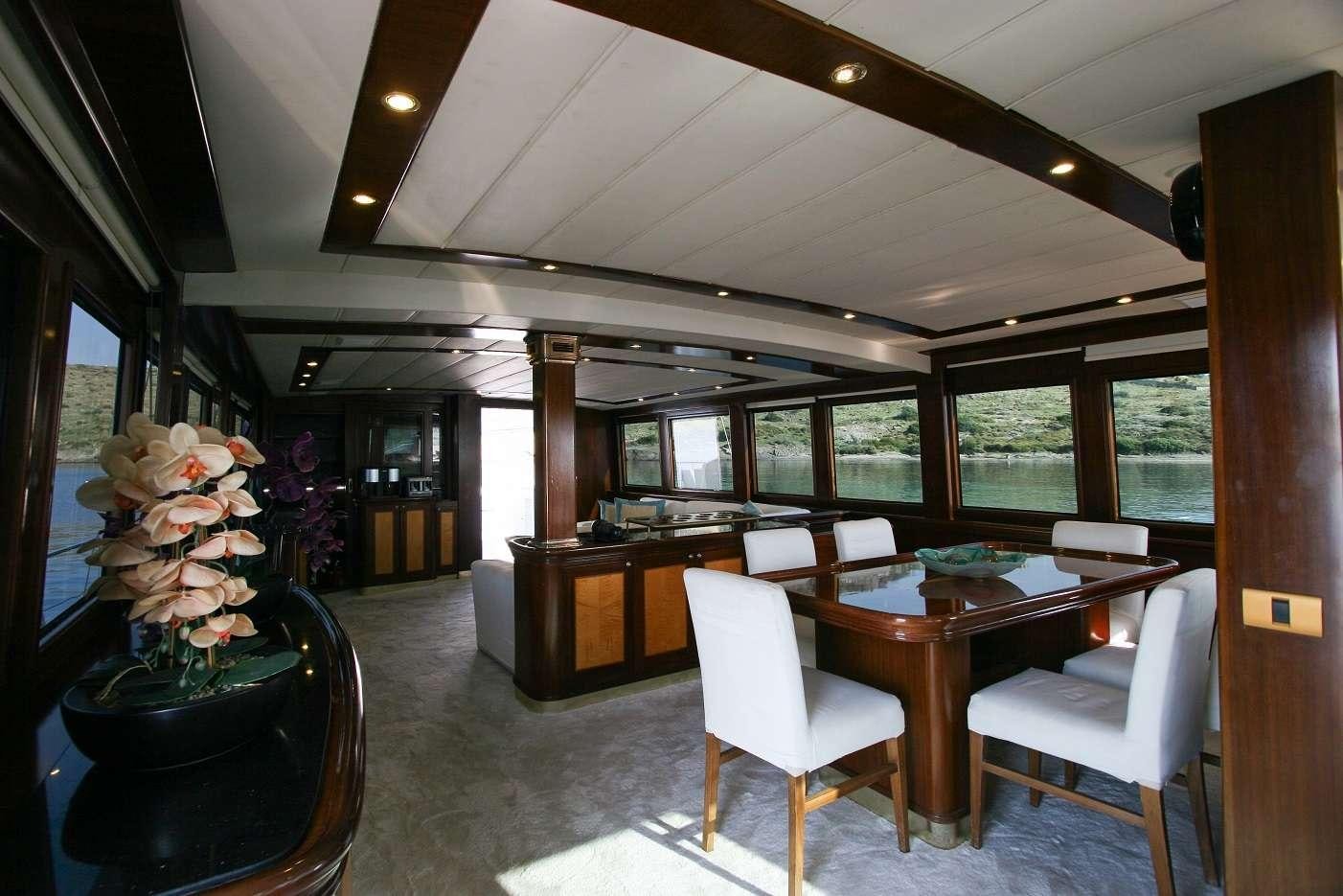 a room with a table chairs and flowers in it aboard CANEREN Yacht for Charter