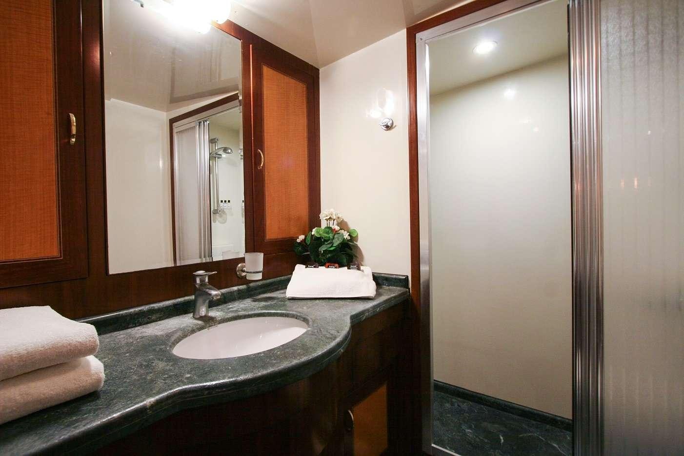 a bathroom with a countertop sink and a mirror aboard CANEREN Yacht for Charter