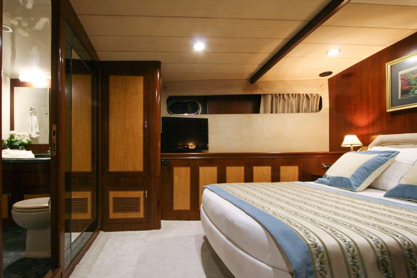 a bedroom with a bed and a television aboard CANEREN Yacht for Charter