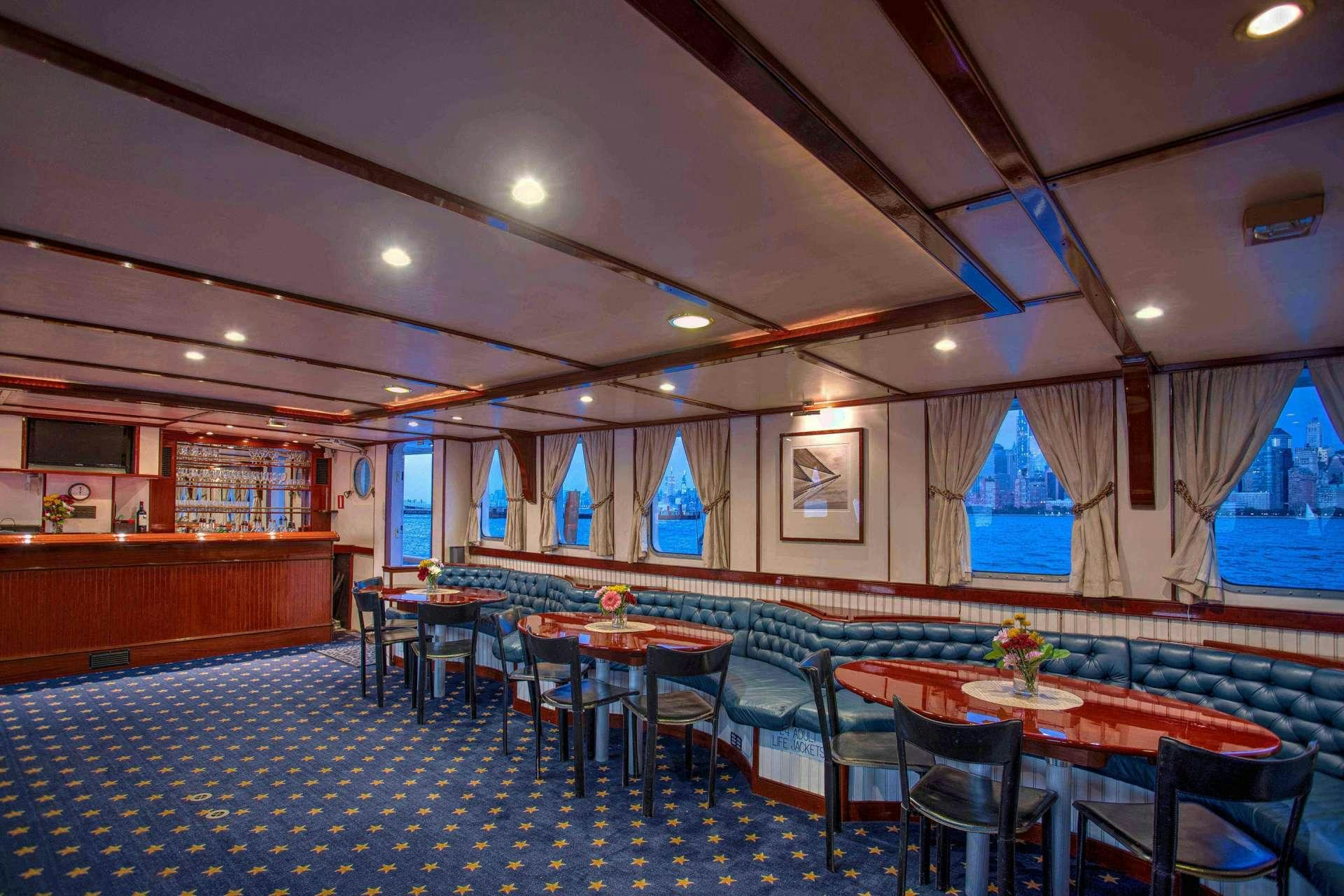 a room with tables and chairs aboard ARABELLA II Yacht for Charter