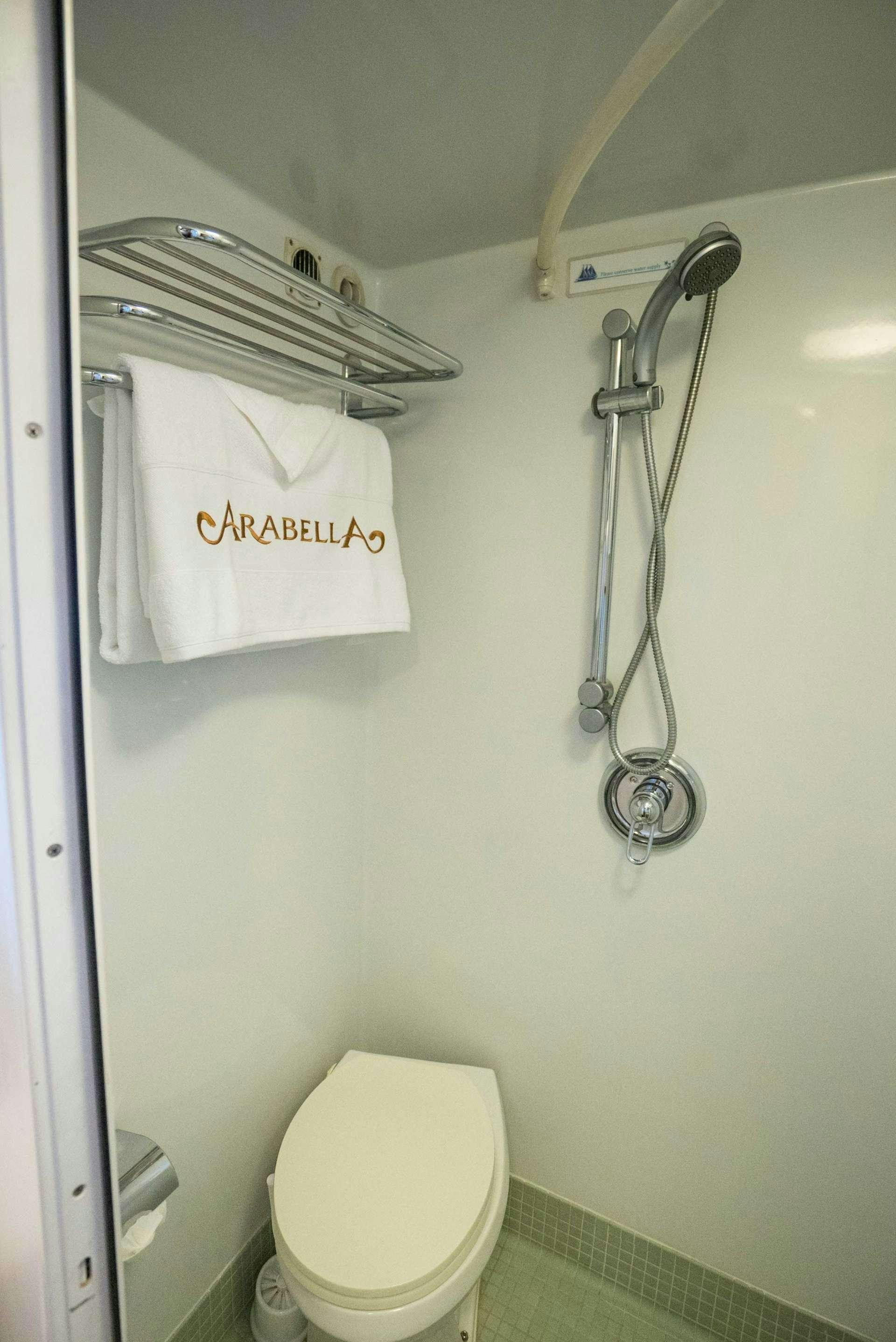 a toilet with a sign on the wall aboard ARABELLA II Yacht for Charter