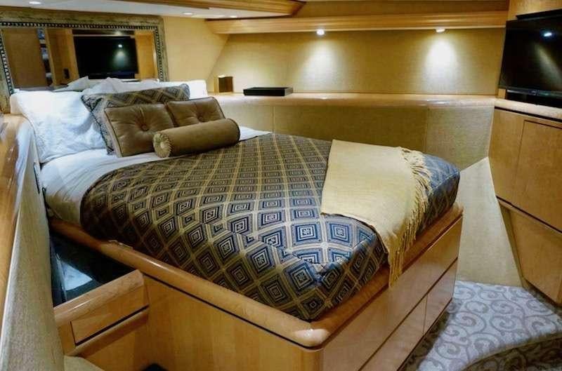 a bed with a blue comforter aboard DENISE ROSE Yacht for Charter