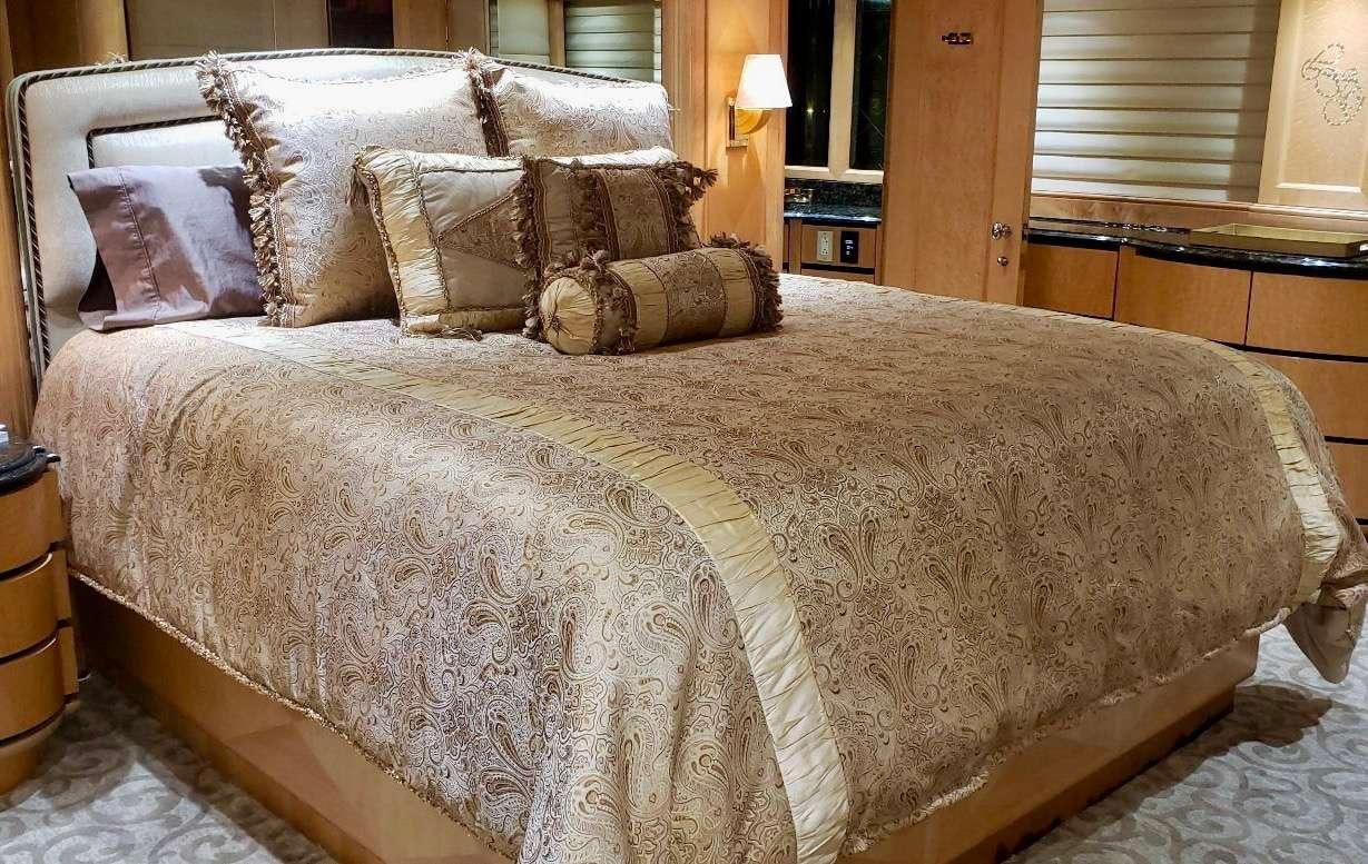 a bed with a white comforter aboard DENISE ROSE Yacht for Charter