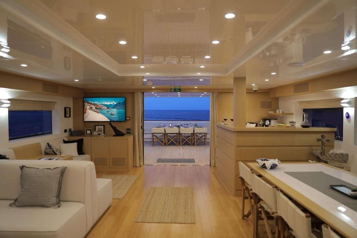 a large room with a table and chairs and a tv aboard OTTAWA IV Yacht for Charter