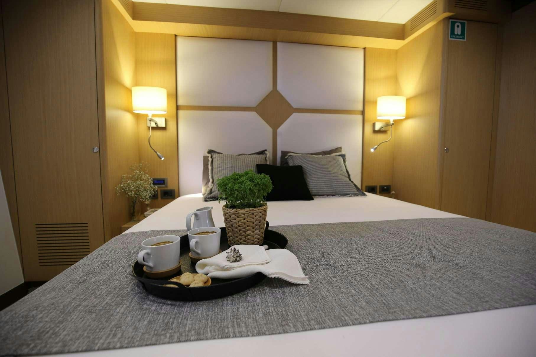 a bed with a tray of food aboard OTTAWA IV Yacht for Charter