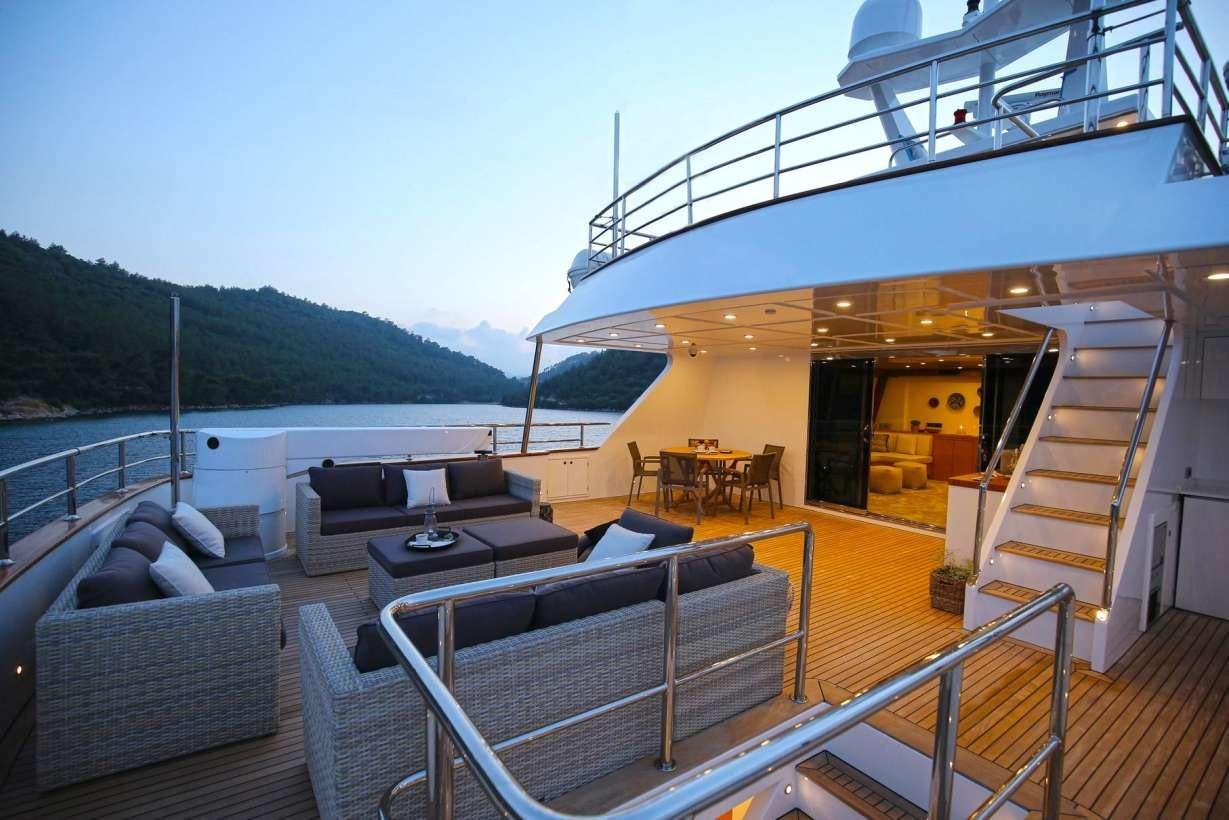 a deck with a large body of water and a deck with a couch and a railing aboard OTTAWA IV Yacht for Charter