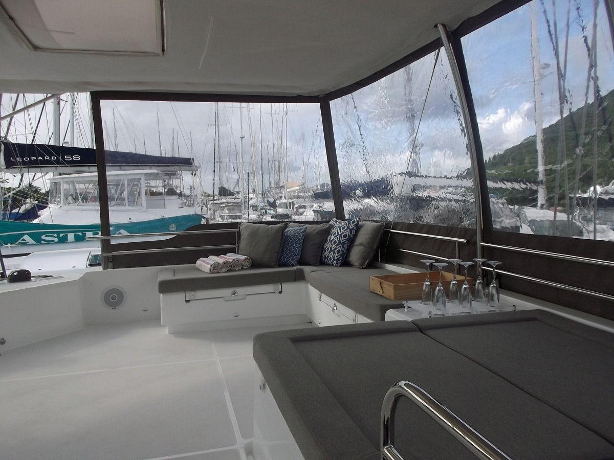 a room with a couch and a table with a bed and a window aboard COOL RUNNINGS IV Yacht for Charter