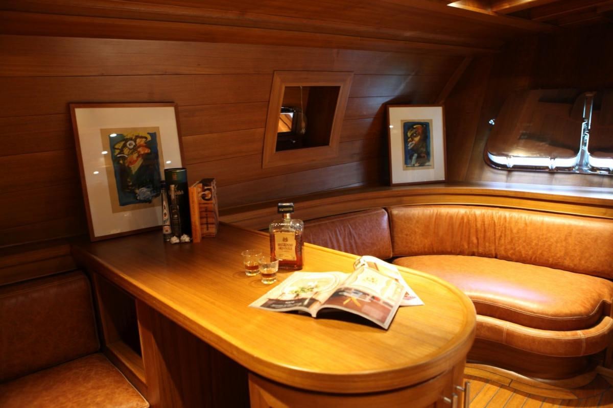a room with a couch and a table with a bottle of wine aboard CAKIRYILDIZ Yacht for Charter