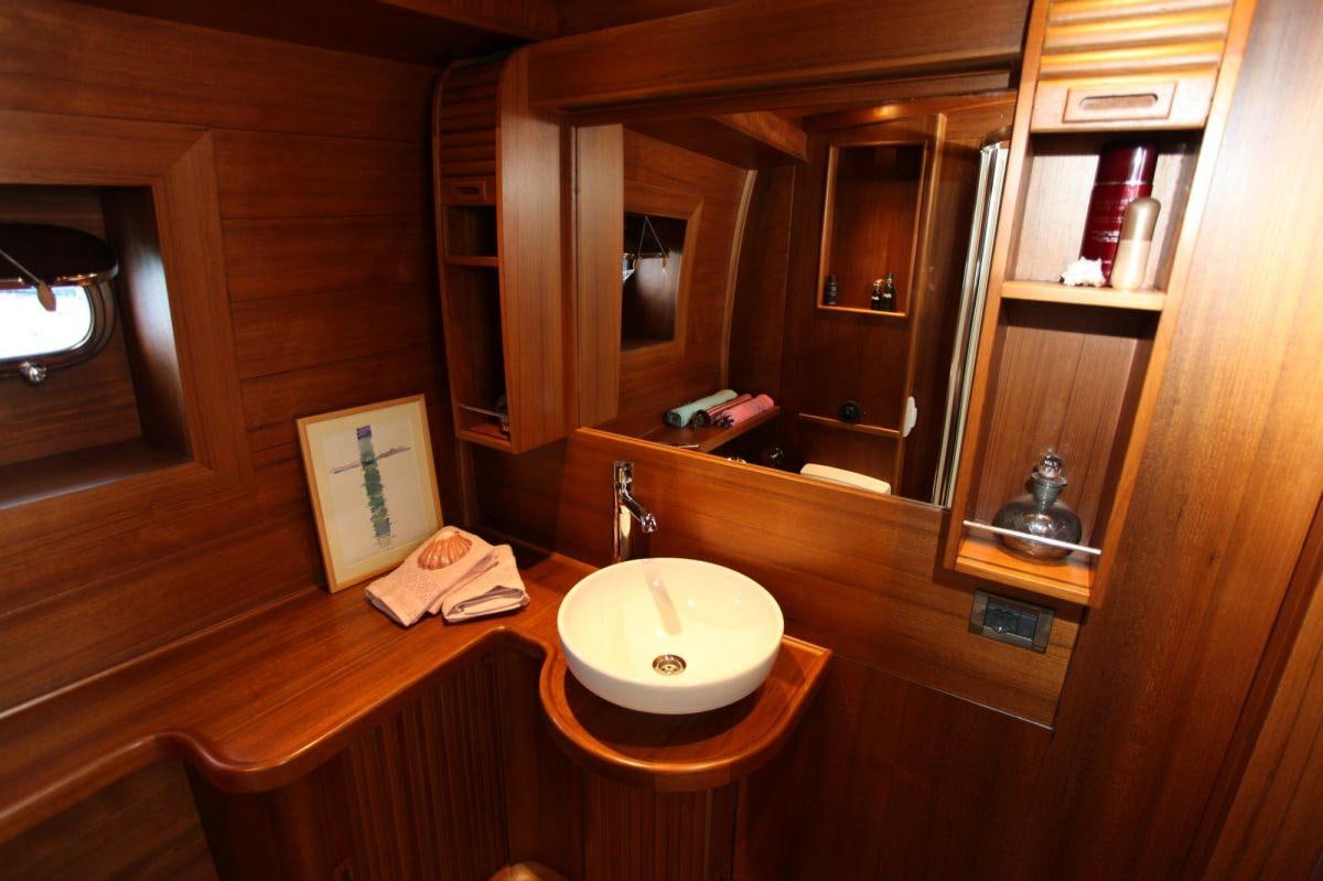 a wooden table with a chair and a mirror aboard CAKIRYILDIZ Yacht for Charter