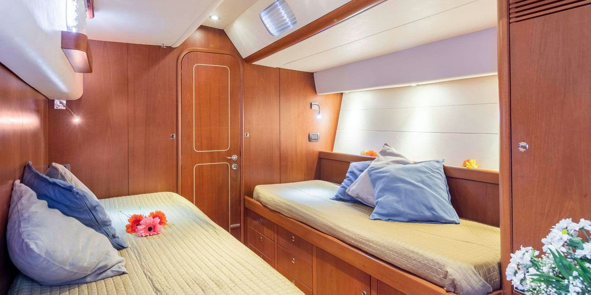 a room with a bed and a wood cabinet aboard ELISE WHISPER Yacht for Charter