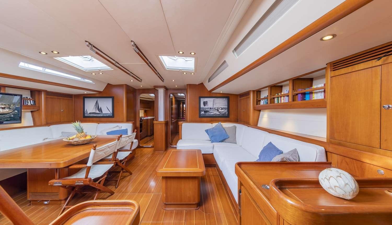 a room with a couch and a table and a television aboard ELISE WHISPER Yacht for Charter