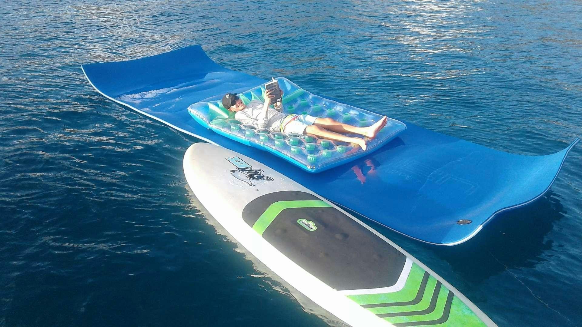 a person lying on a raft in the water aboard ELIXIR Yacht for Charter