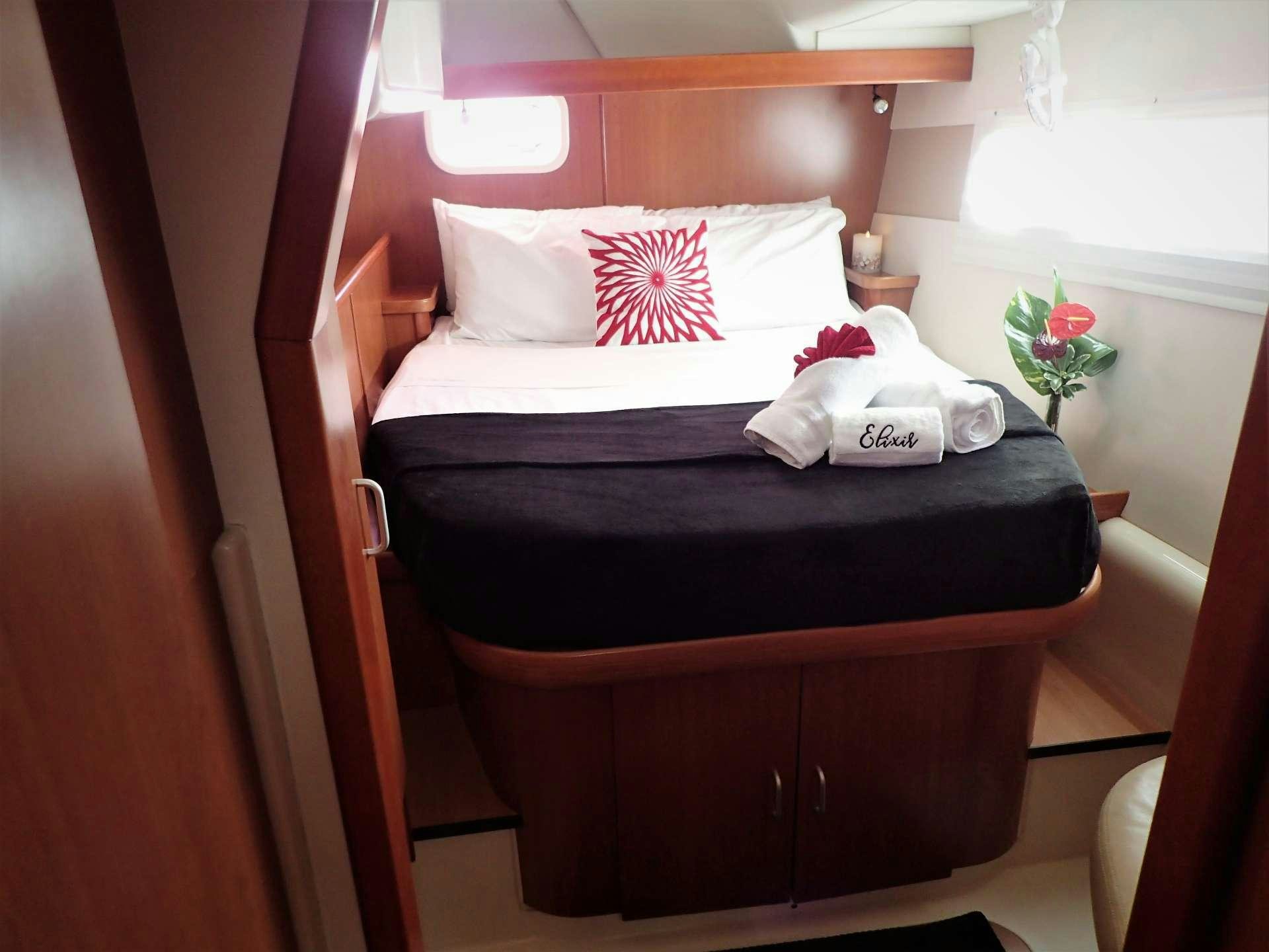 a bed with white sheets and pillows aboard ELIXIR Yacht for Charter
