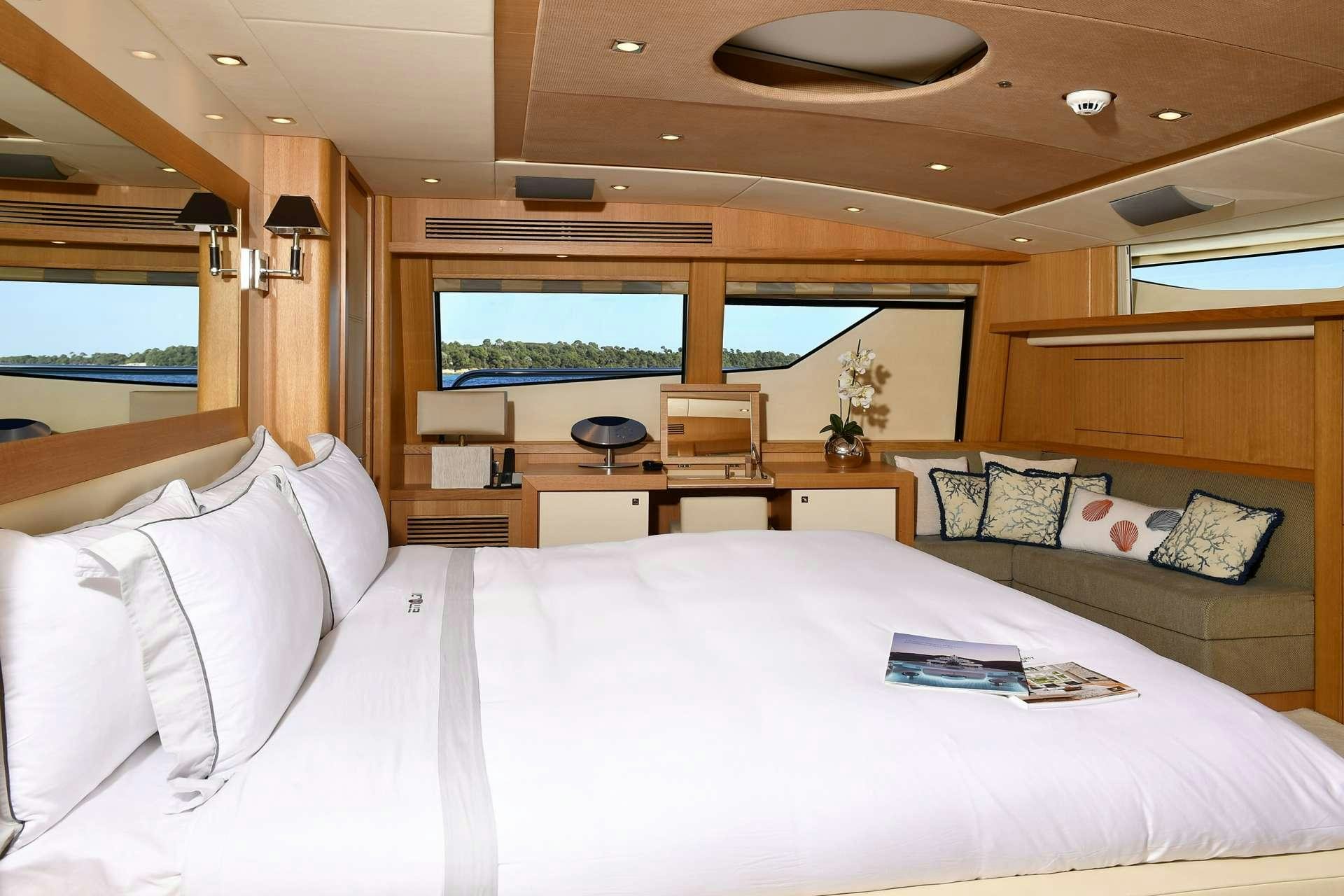 a bed with a white sheet and a white bed spread aboard TENACITY Yacht for Charter