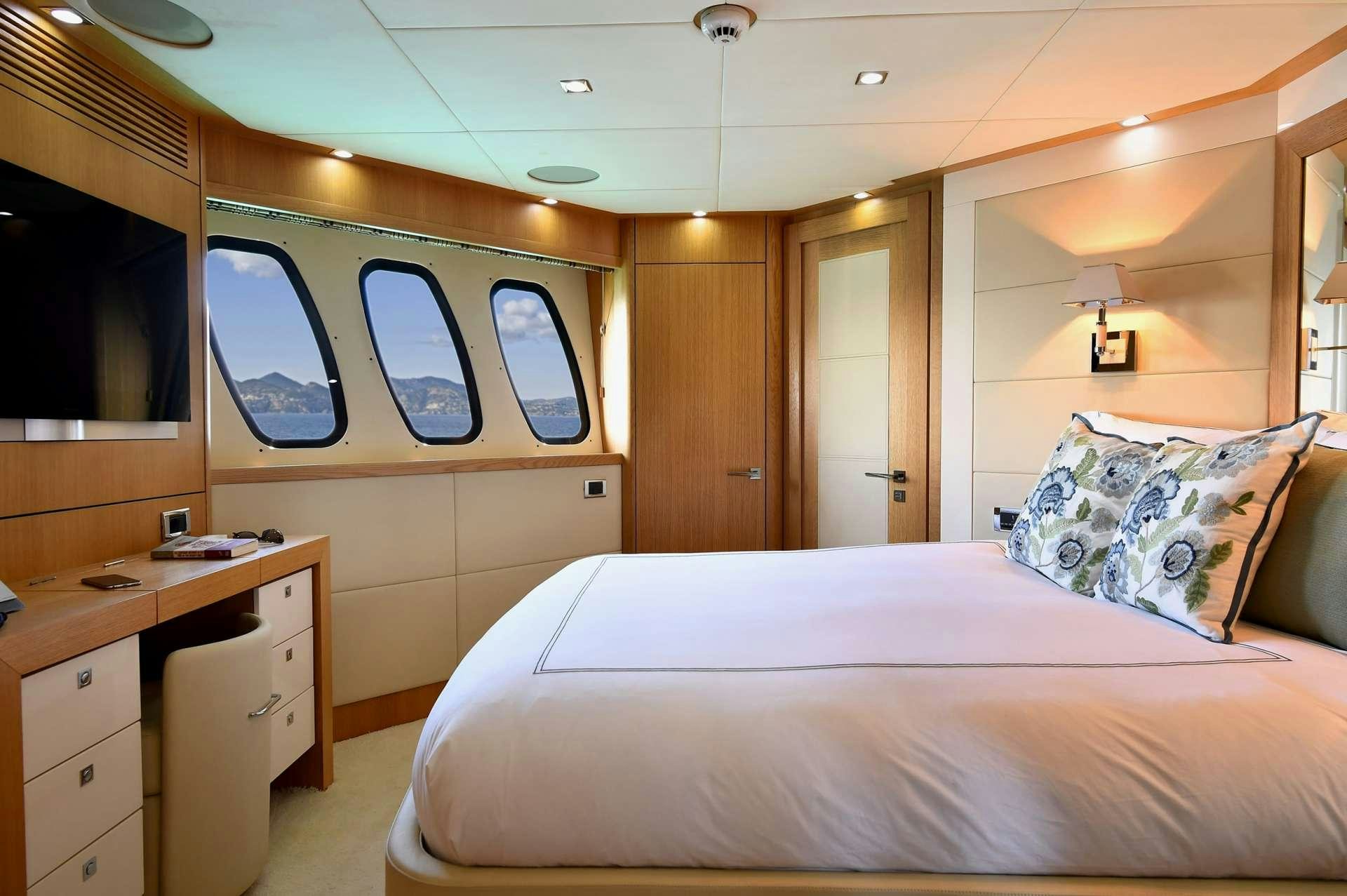 a bedroom with a bed and a desk aboard TENACITY Yacht for Charter