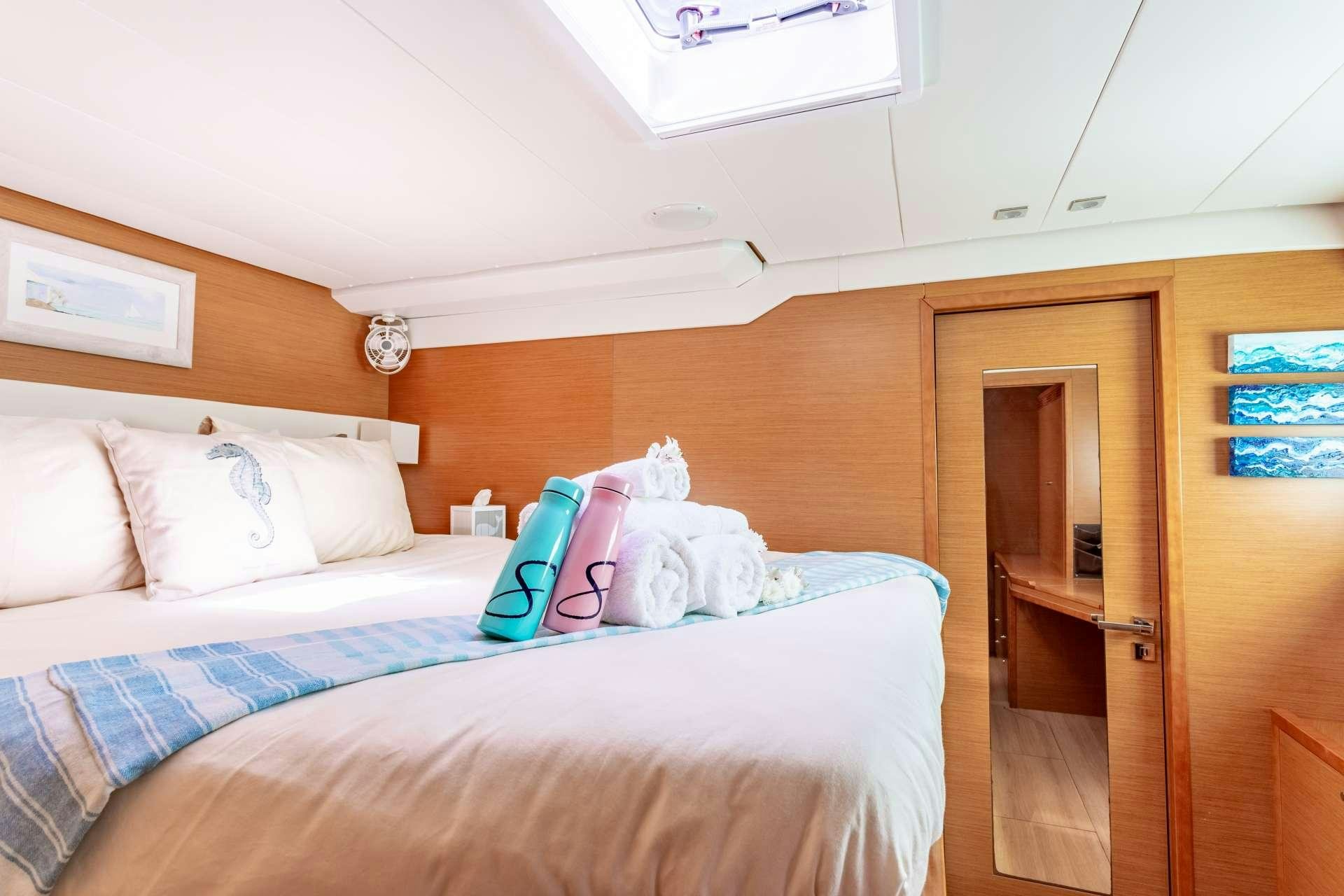 a bed with a white comforter and pillows aboard SERENITY NOW Yacht for Charter