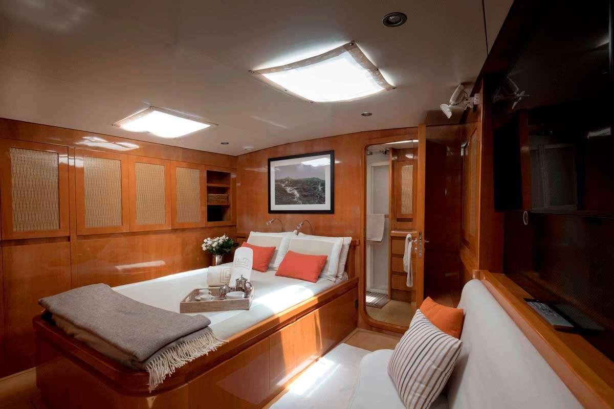 a room with a bed and a table aboard LOGICA/QUINTA SANTA MARIA Yacht for Charter