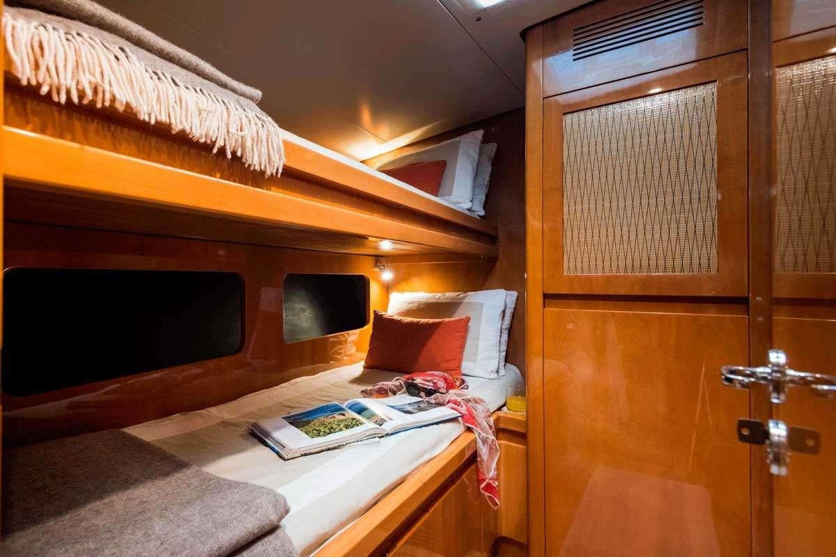 a bed with a desk and a television in a room aboard LOGICA/QUINTA SANTA MARIA Yacht for Charter