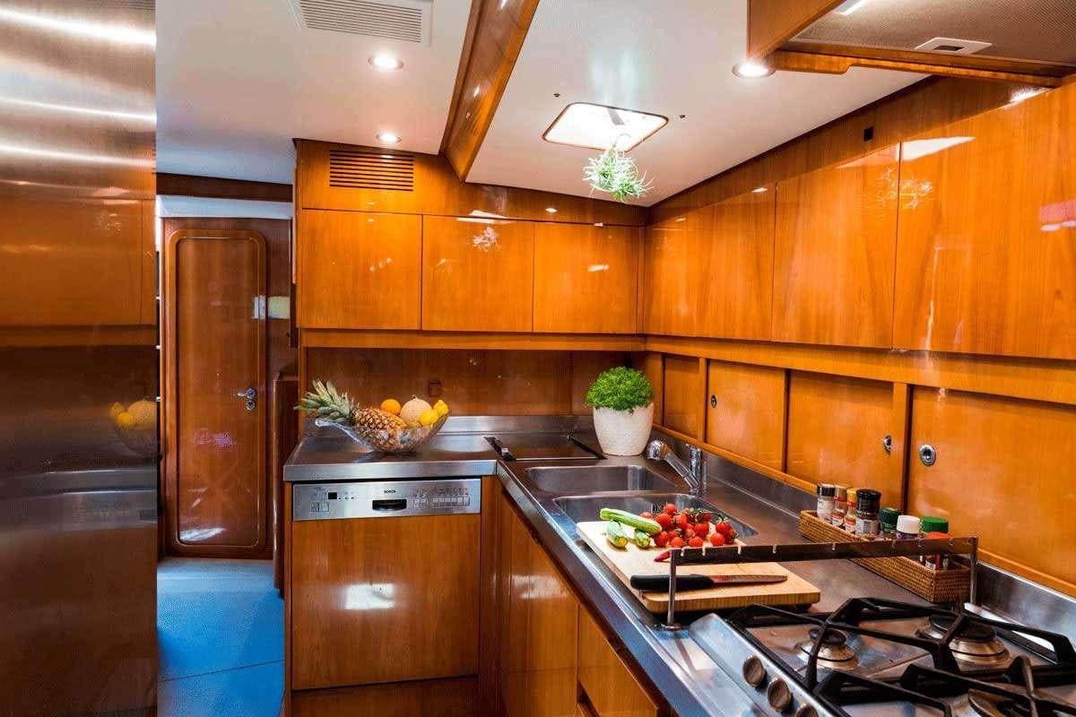 a kitchen with wooden cabinets aboard LOGICA/QUINTA SANTA MARIA Yacht for Charter