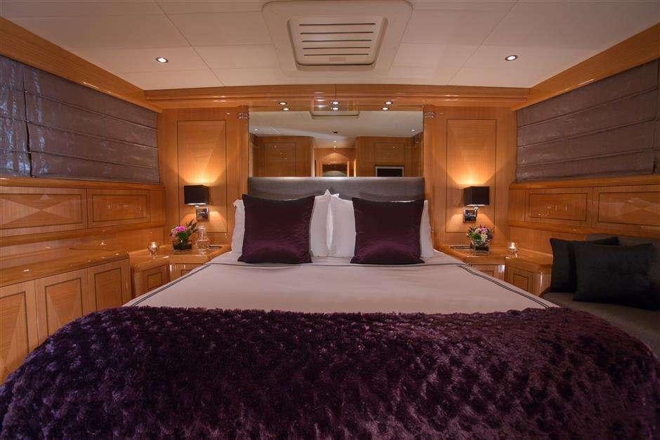 a large bed with purple and white sheets aboard YCM Yacht for Charter