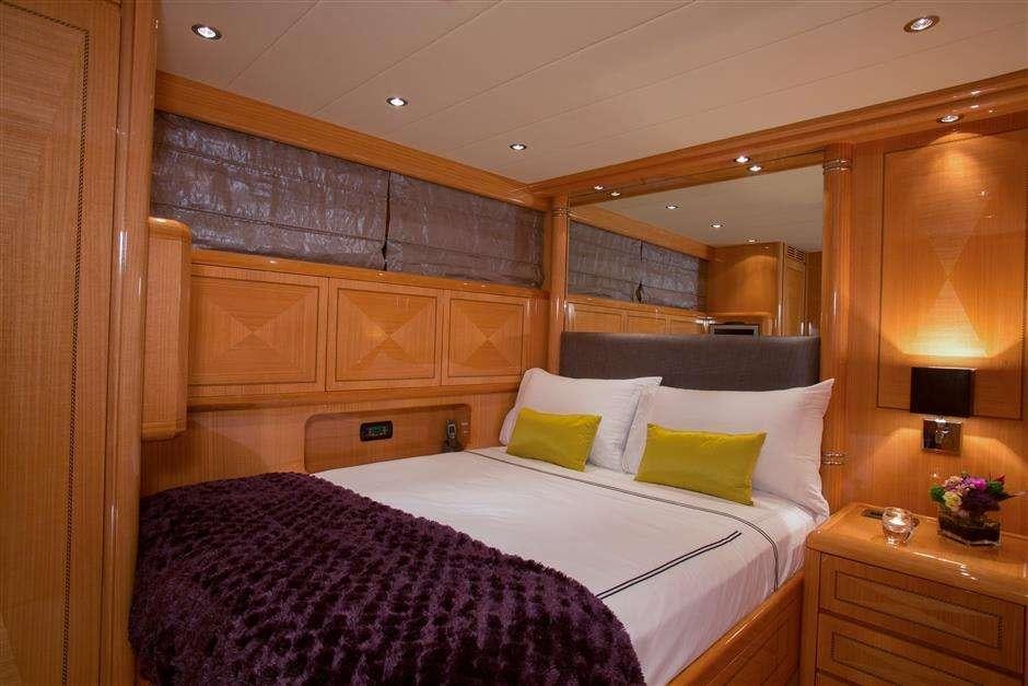 a bed with a purple and white blanket and pillows aboard YCM Yacht for Charter