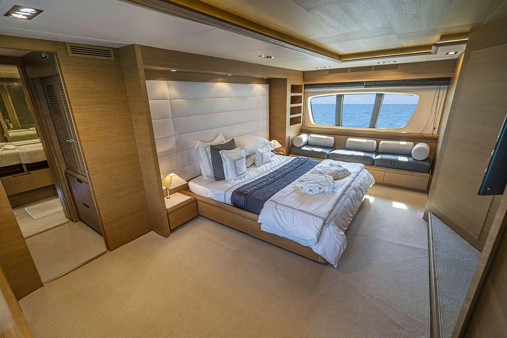 a room with a bed and a window aboard INTERVENTION Yacht for Charter