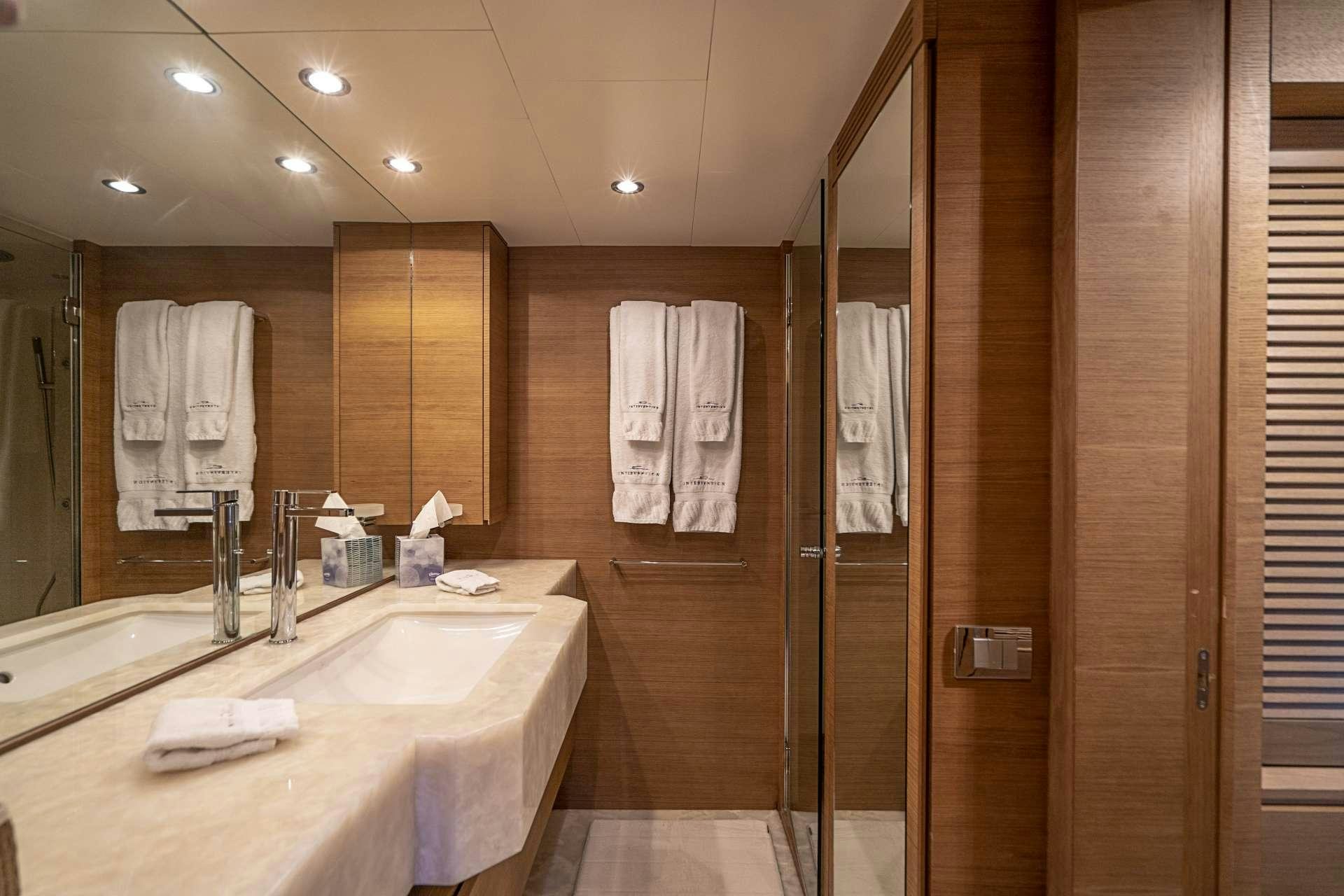 a bathroom with a countertop sink and a shower unit aboard INTERVENTION Yacht for Charter