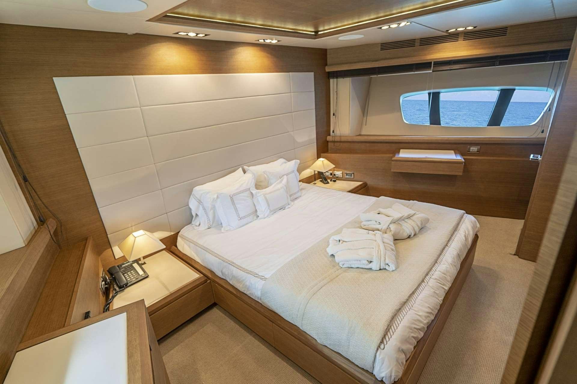 a room with a bed and a window aboard INTERVENTION Yacht for Charter