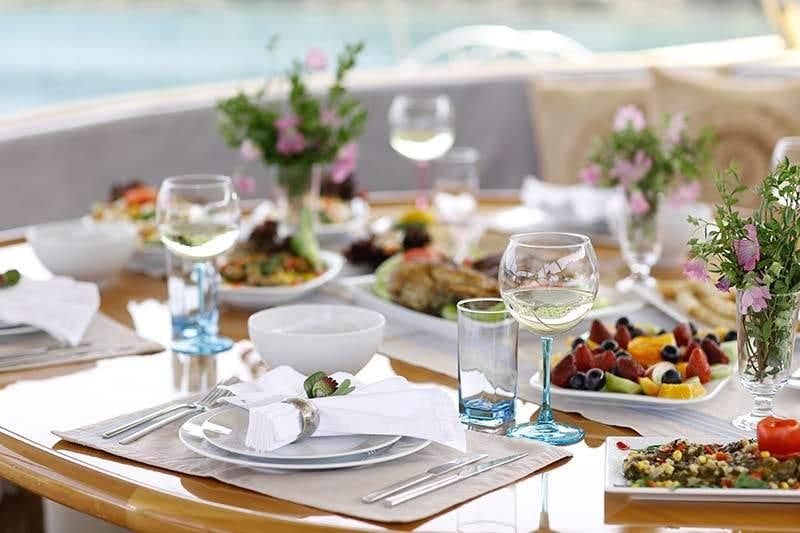 a table with food and glasses aboard SILVER MOON Yacht for Charter