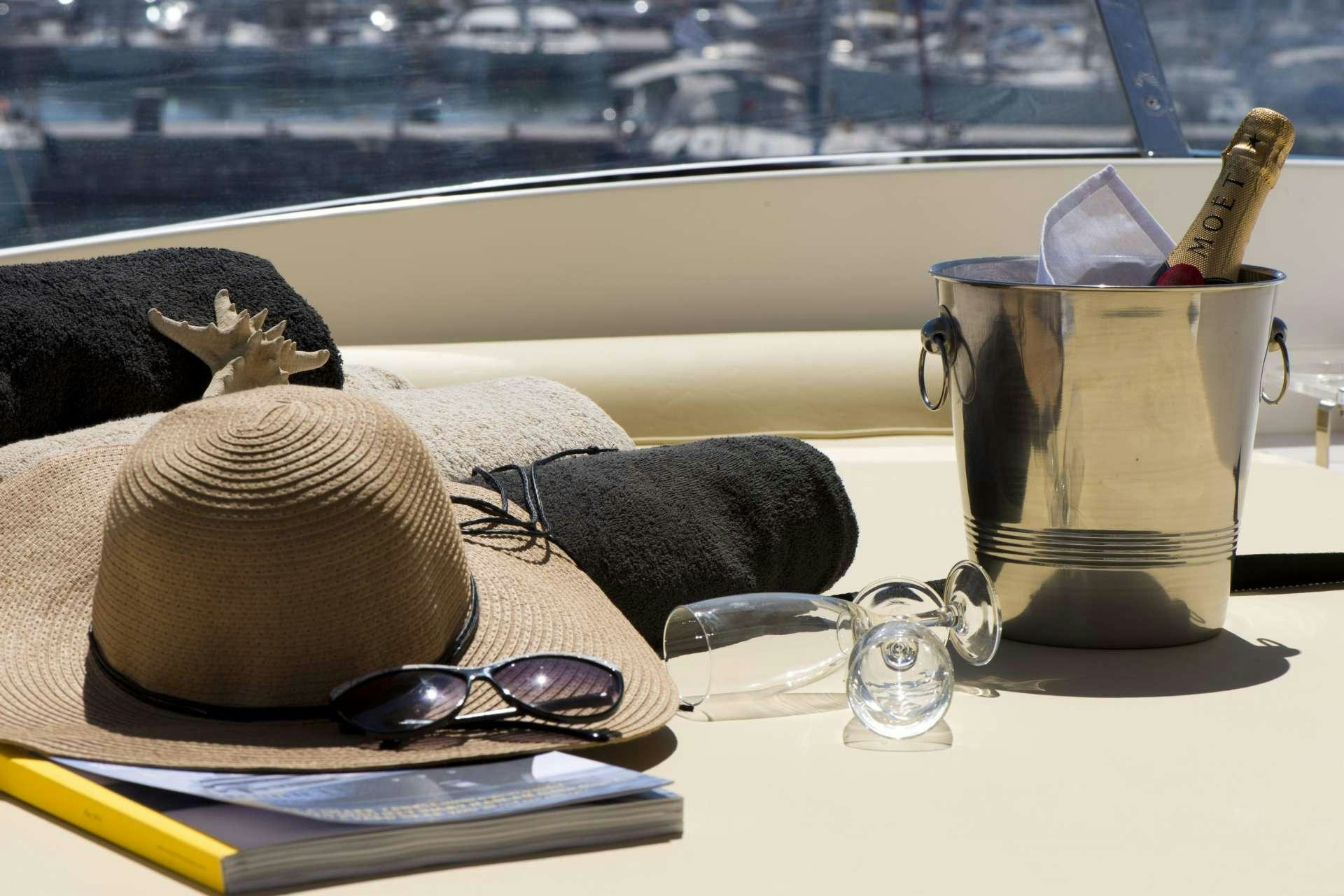 a hat and sunglasses on a table aboard JULY Yacht for Charter
