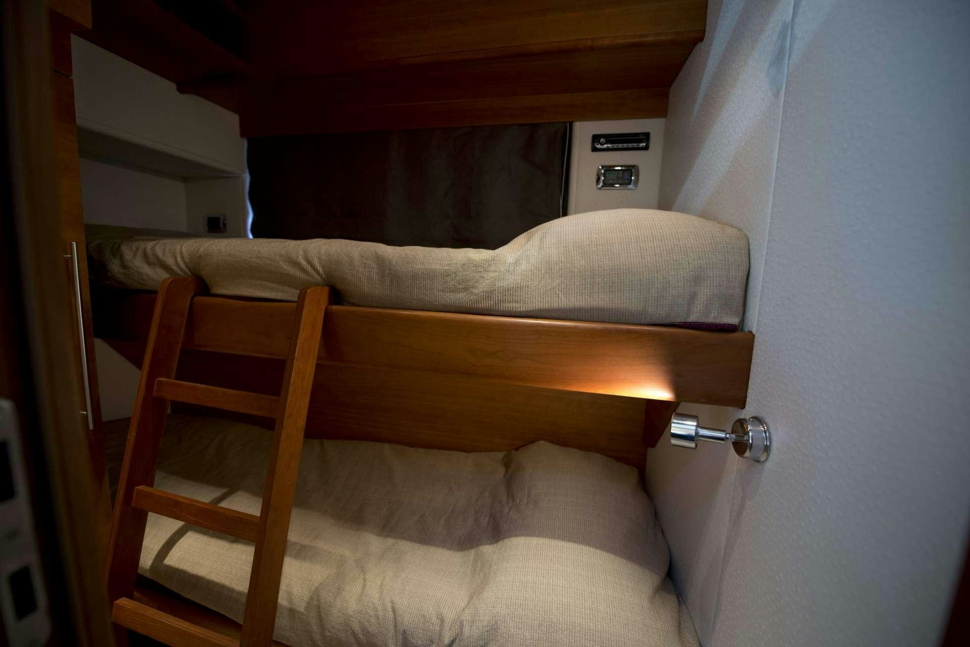 a bed with a wooden headboard aboard JULY Yacht for Charter