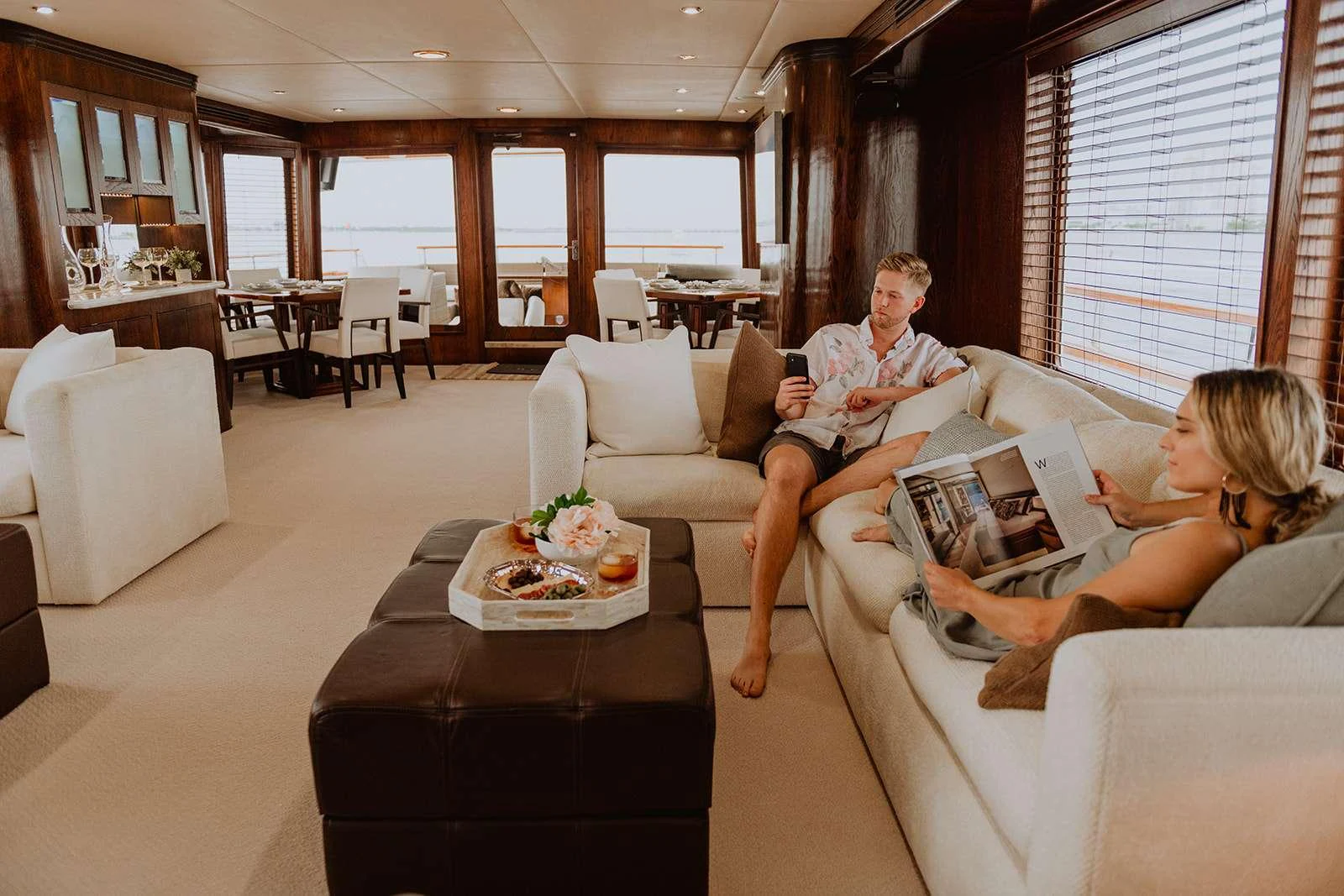 The yacht's interior features a cozy lounge area with plush seating and a dining space in the background. aboard SKY Yacht for Charter