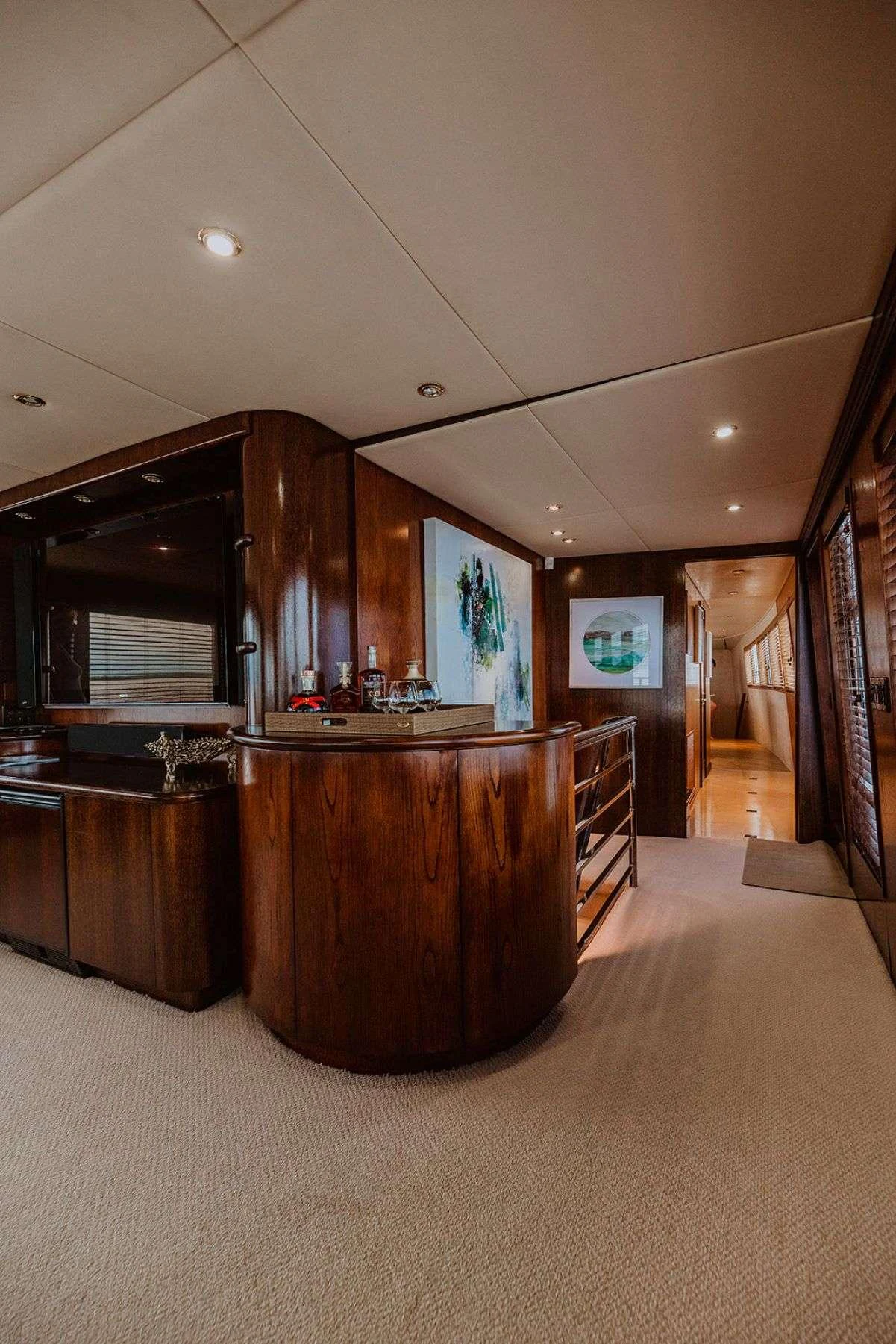 The yacht's interior features a stylish hallway with elegant wood finishes and tasteful artwork. aboard SKY Yacht for Charter