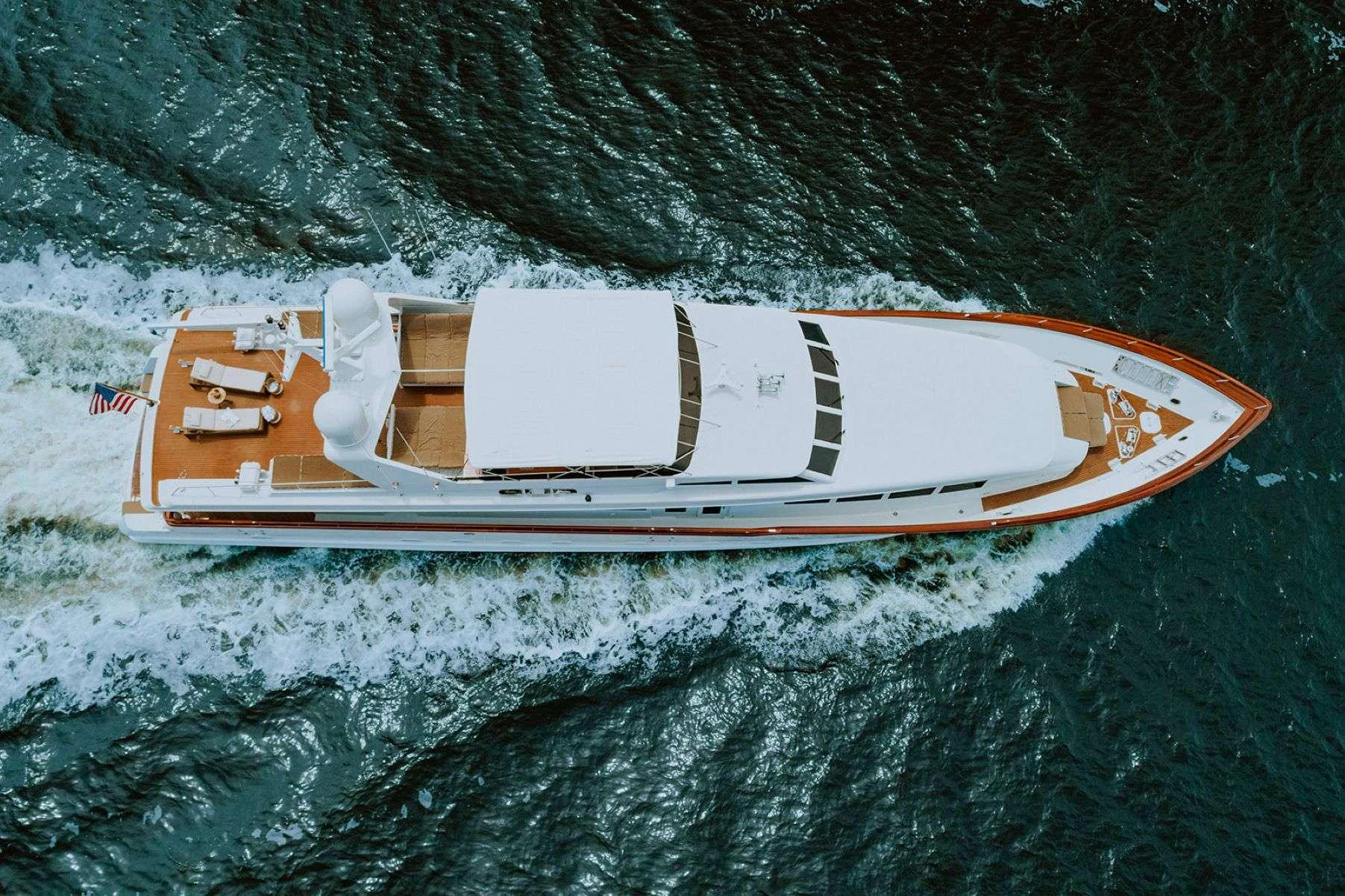 A sleek yacht cruises through the water, showcasing its elegant design and spacious deck areas. aboard SKY Yacht for Charter