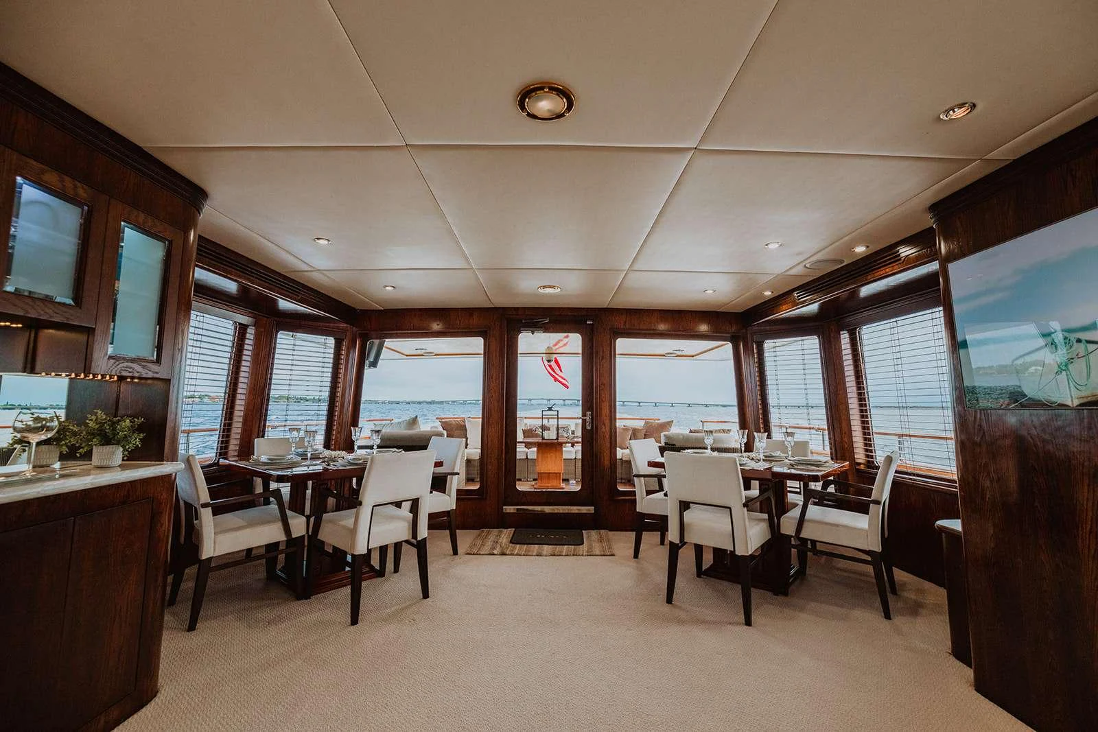 The yacht's interior dining area features elegant seating with panoramic views. aboard SKY Yacht for Charter