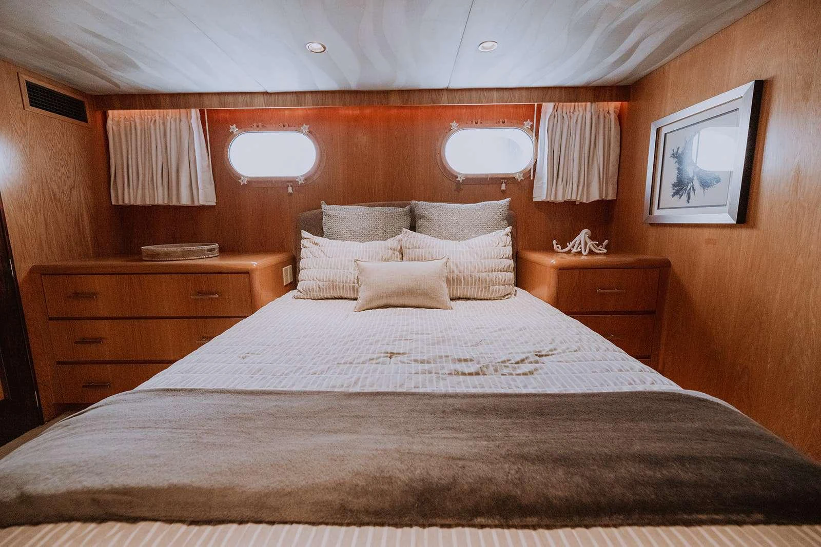 A cozy stateroom featuring a comfortable bed with plush pillows and warm wooden accents. aboard SKY Yacht for Charter