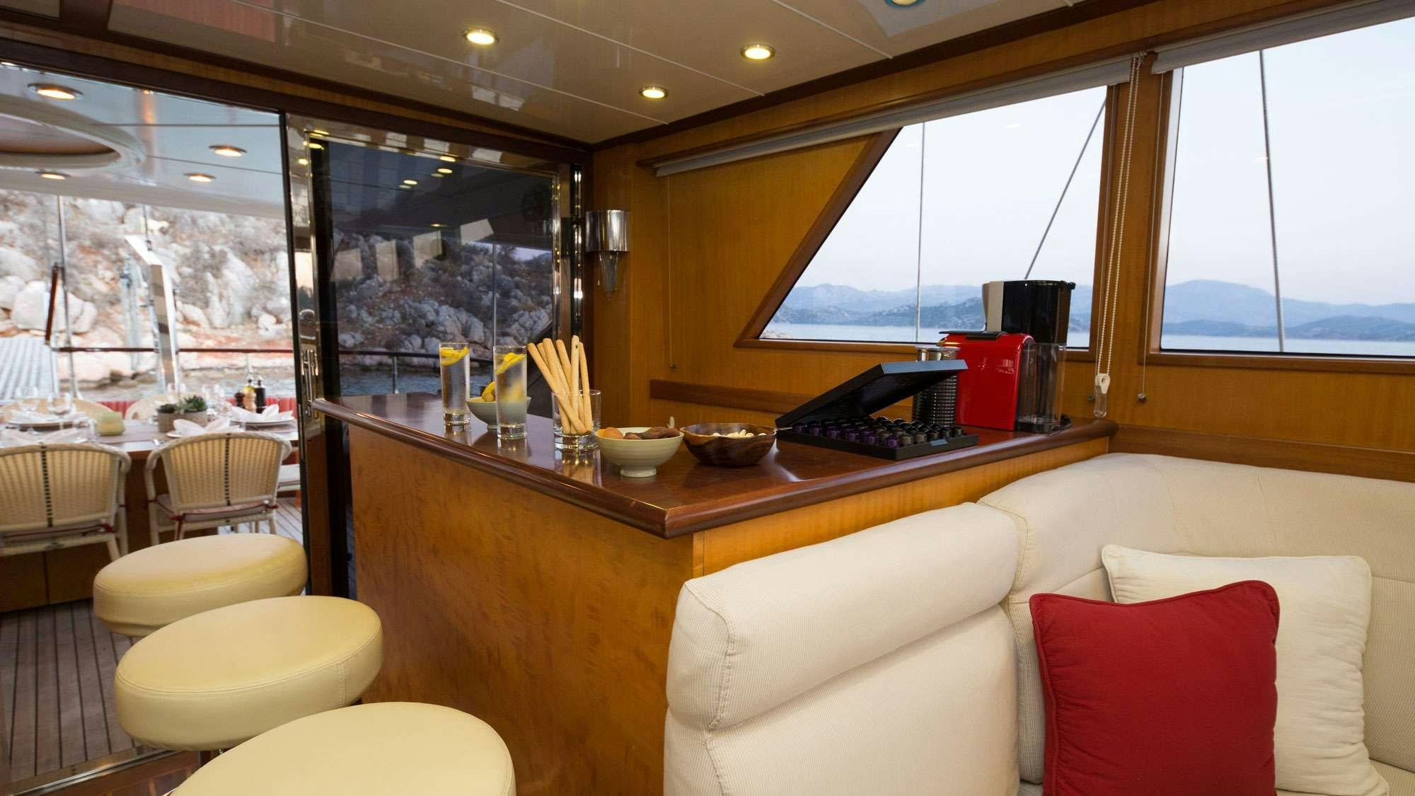 a room with a couch and a table with a laptop on it aboard SERENITY 86 Yacht for Charter