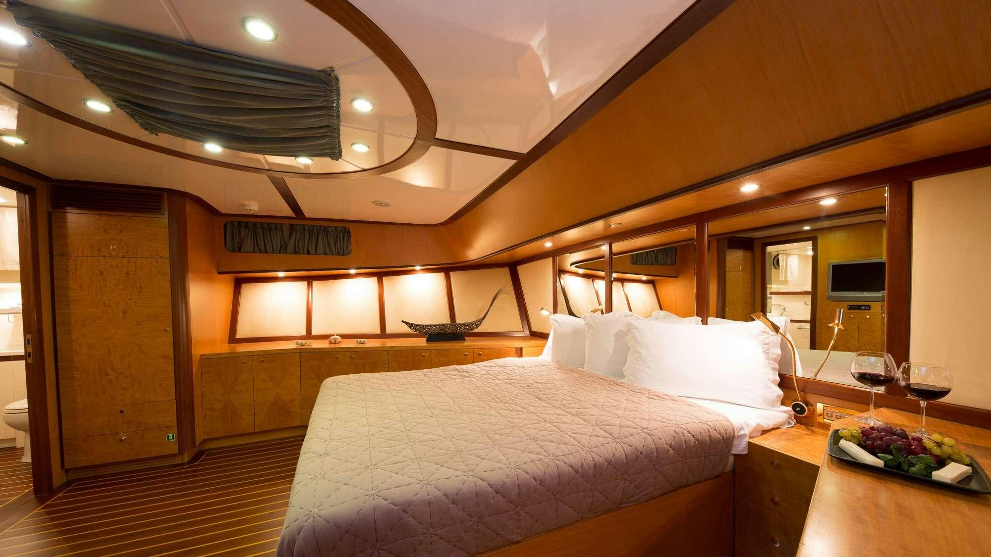 a hotel room with a bed and glass of wine aboard SERENITY 86 Yacht for Charter